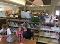 Amy DeYoung, of Ham Lake, reads with her daughters Arielle and Lillia on a recent afternoon in Centennial Library.