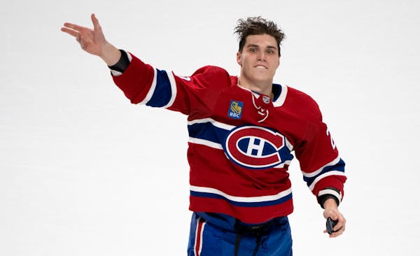 First star of the game, Montreal Canadiens' Juraj Slafkovsky, tosses pucks to the crowd after defeating the Arizona Coyotes in NHL hockey action in Mo