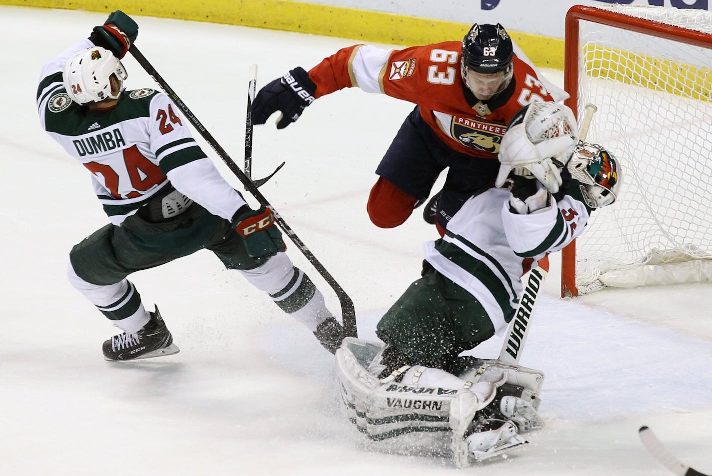 Florida Panthers' Evgenii Dadonov (63), of Russia, is called for goalie interference against Minnesota Wild goalie Alex Stalock, right, as Wild's Matt Dumba (24) defends during the second period of an NHL hockey game, Friday, Dec. 22, 2017, in Sunrise, Fla. (AP Photo/Luis M. Alvarez)