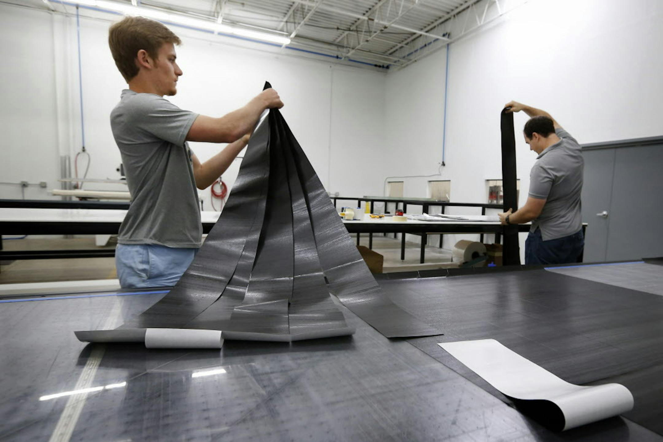 Bryan Kennedy and Jason Daniel stacked strips of cut carbon fiber for lacrosse sticks at Epoch Lacrosse in Roseville. ] CARLOS GONZALEZ cgonzalez@startribune.com - May 24, 2016, Roseville, MN, Epoch Lacrosse, Roseville-based Epoch Lacrosse moved into 10,000 sf of new space last fall. Now they've launched C6 Composites to design, engineer and produce carbon fiber lacrosse equipment.