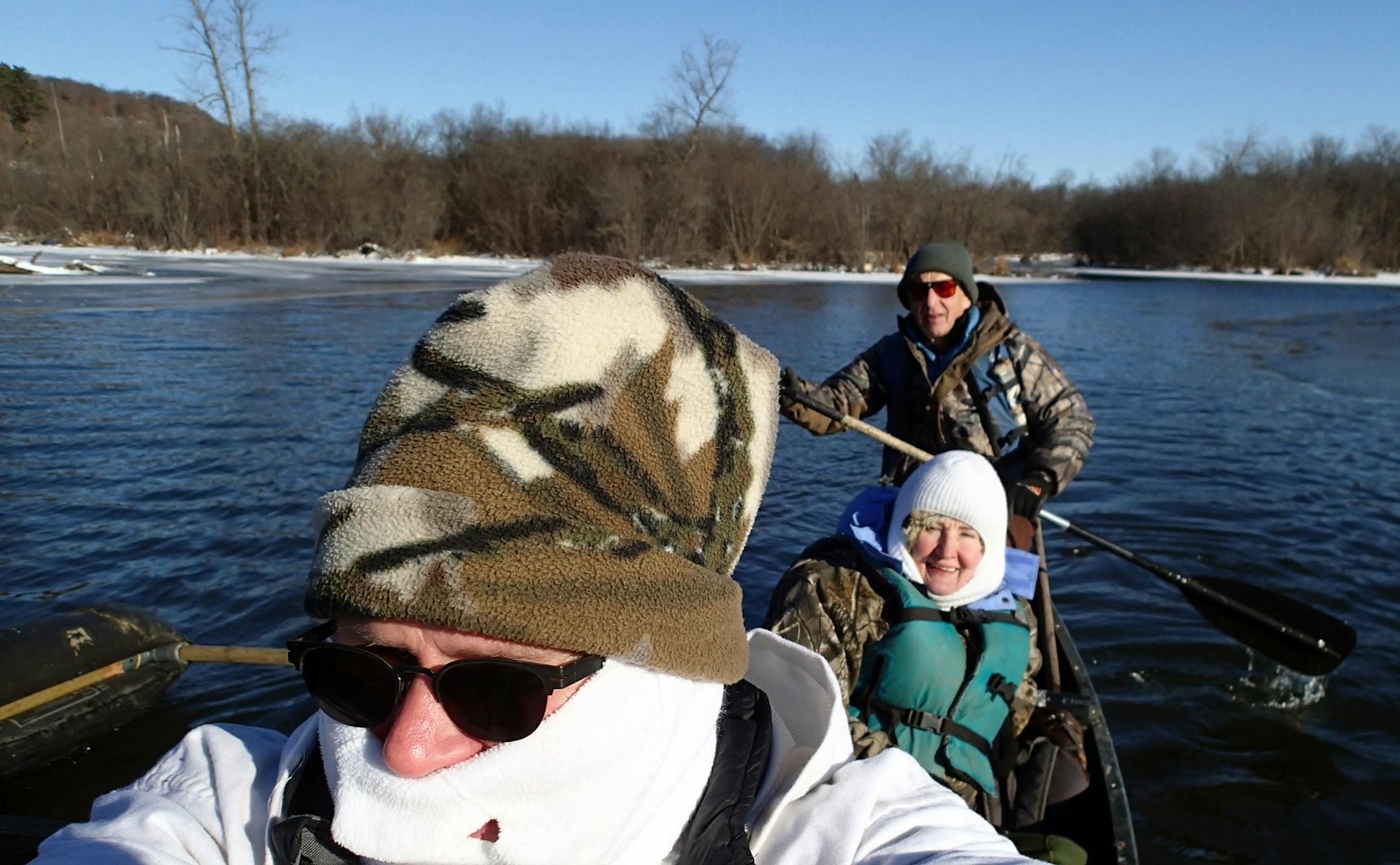 Wendell Diller, in stern, his wife, Gallina, and Dennis Anderson paddle their canoe in the backwaters of the St. Croix River Valley Thursday morning, in anticipation of a cold-weather waterfowl hunt.