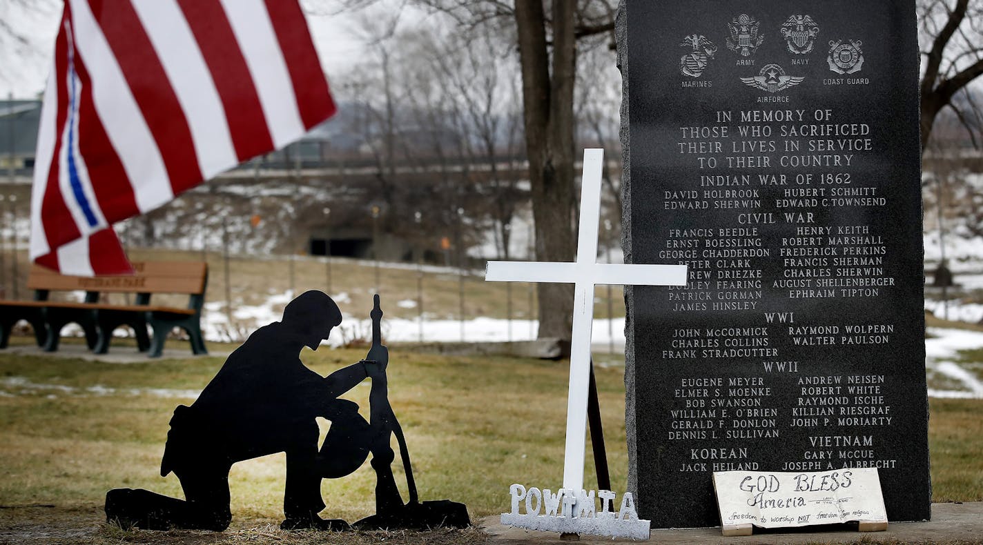 A cross was removed from a kneeling soldier at the veterans memorial park in Belle Plaine, MN. Advocates for the cross have been placing new ones at the park and guarding them throughout the day. ] CARLOS GONZALEZ cgonzalez@startribune.com - January 24, 2017, Belle Plaine, MN, A group of flag-toting Belle Plaine residents has taken it upon themselves to keep guard over the small town's veteran's memorial, rebelling against city's decision to remove a cross from a fallen soldier's grave marker. O