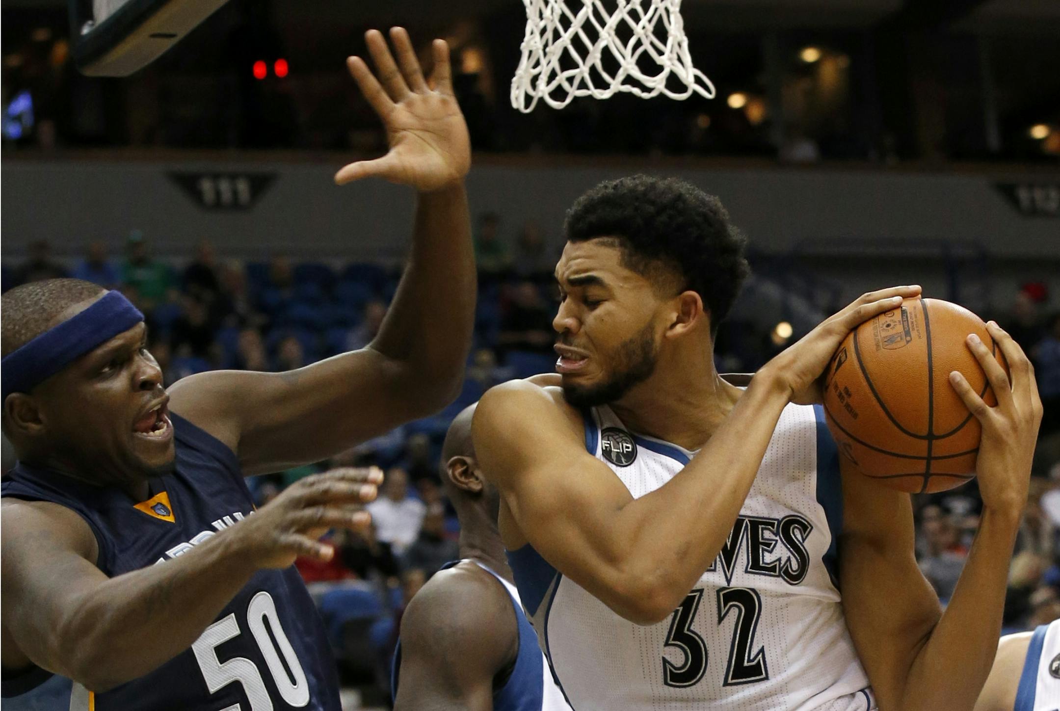 Minnesota Timberwolves center Karl-Anthony Towns (32) pulls down a rebound against Memphis Grizzlies forward Zach Randolph (50) during the second half of an NBA basketball game in Minneapolis, Sunday, Nov. 15, 2015. The Grizzlies won 114-106.