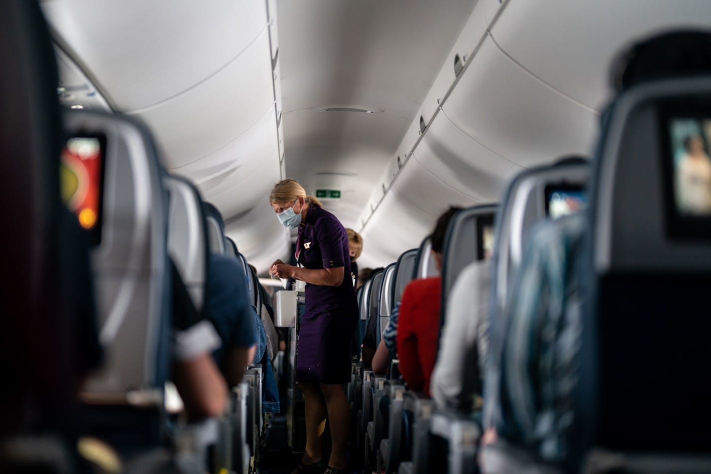 Flight attendants hand out refreshments to a packed Delta Air Lines flight on Friday, May 21, 2021. Delta wants all air carriers to share no-fly lists with the FAA. Unruly passengers have become a problem for airlines during the pandemic. (Kent Nishimura/Los Angeles Times/TNS) ORG XMIT: 27835897W