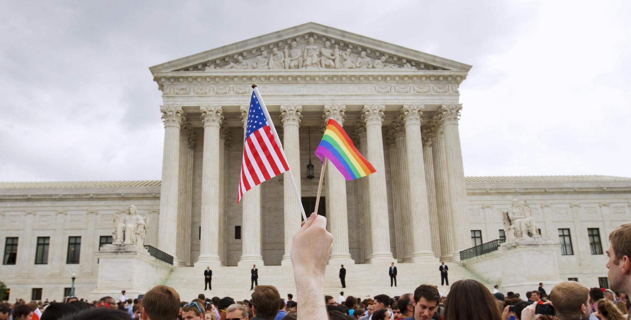 FILE - In this June 26, 2015, file photo, a crowd celebrates outside of the Supreme Court in Washington after the court declared that same-sex couples have a right to marry anywhere in the U.S. On Friday, Aug. 16, 2019, the Justice Department brief filed telling the Supreme Court that federal law allows firing workers for being transgender. The brief is related to a group of three cases that the high court will hear in its upcoming term related to LGBTQ discrimination in the workplace. (AP Photo