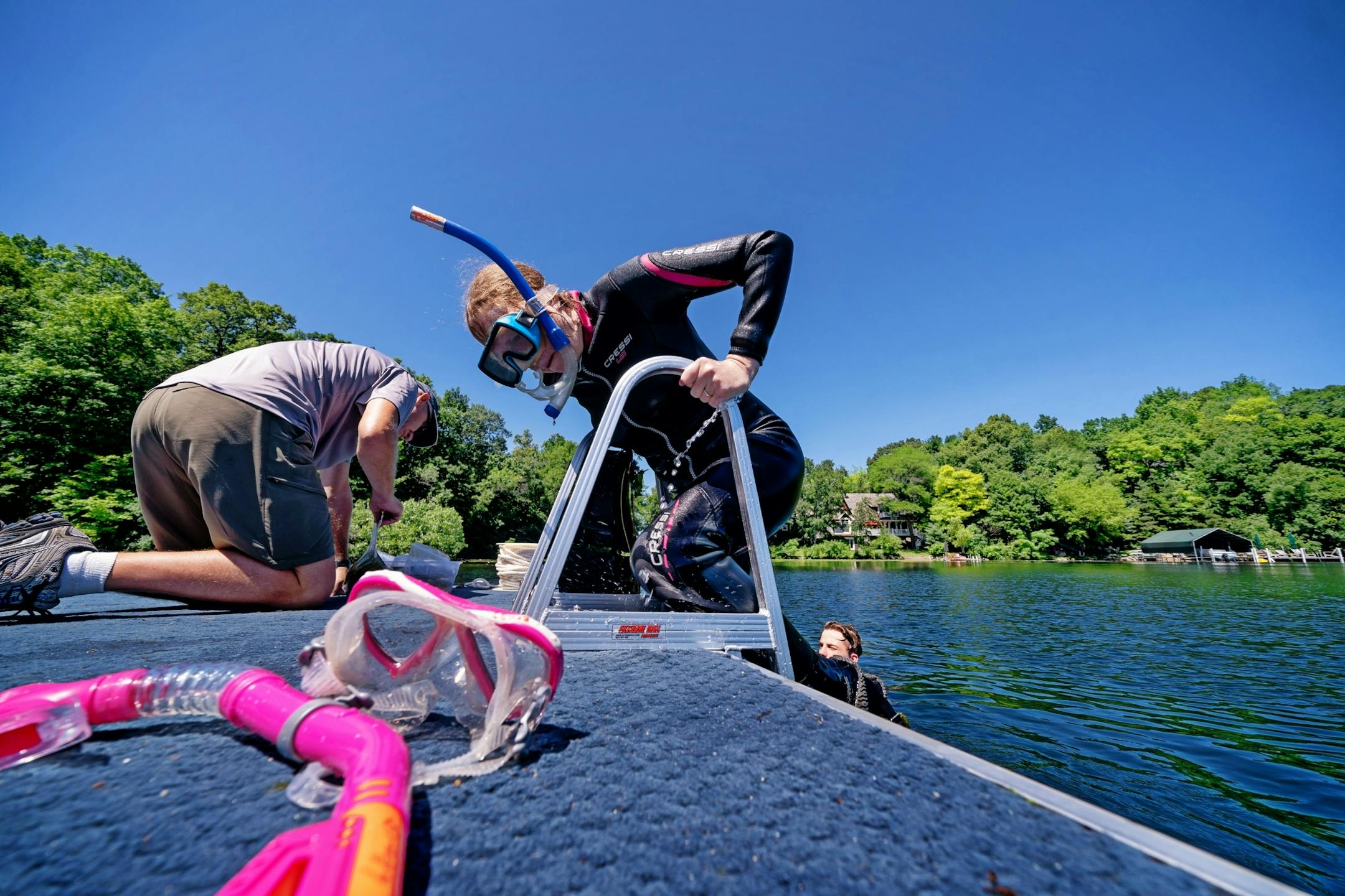 Professor Sallie Sheldon climbed back into the boat after fastening milfoil samples with weevil eggs onto existing milfoil plants in the lake.