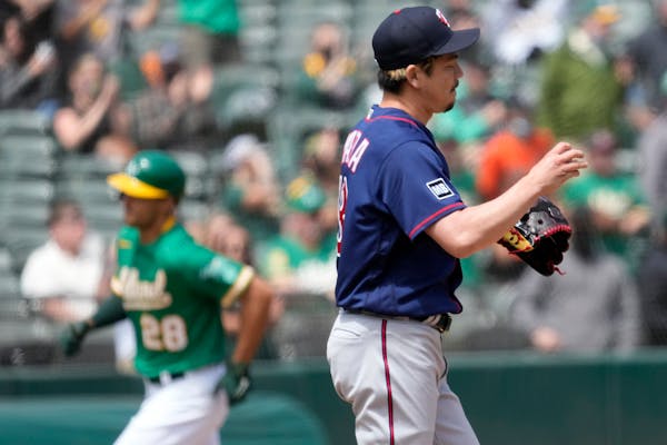 Minnesota Twins starting pitcher Kenta Maeda (18) stands on the mound as Oakland Athletics' Matt Olson (28) rounds the bases after hitting a solo home