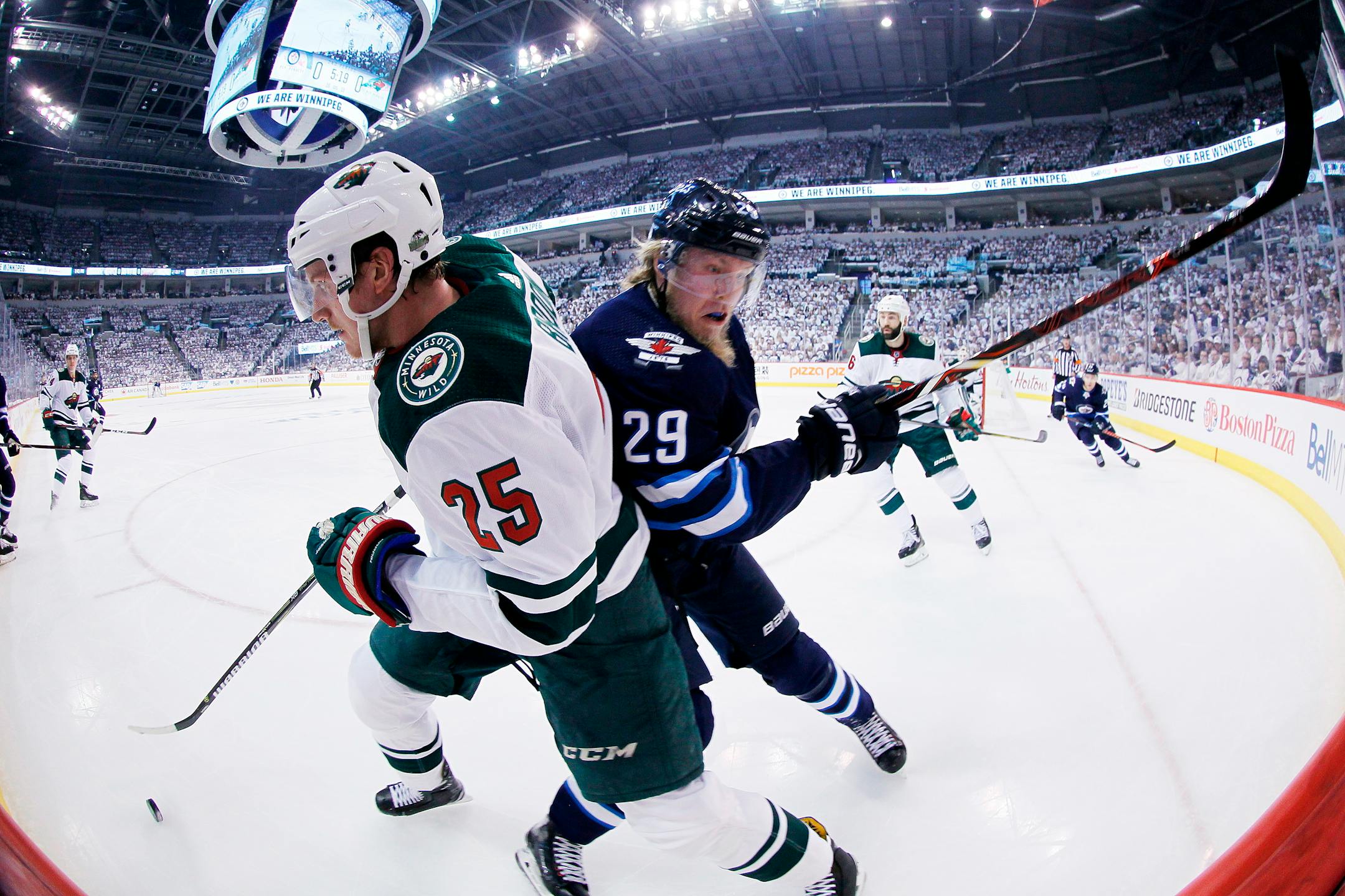 Winnipeg Jets' Patrik Laine (29) checks Minnesota Wild's Jonas Brodin (25) during the second period of Game 1 in an NHL hockey first-round playoff series Wednesday, April 11, 2018, in Winnipeg, Manitoba. (John Woods/The Canadian Press via AP)