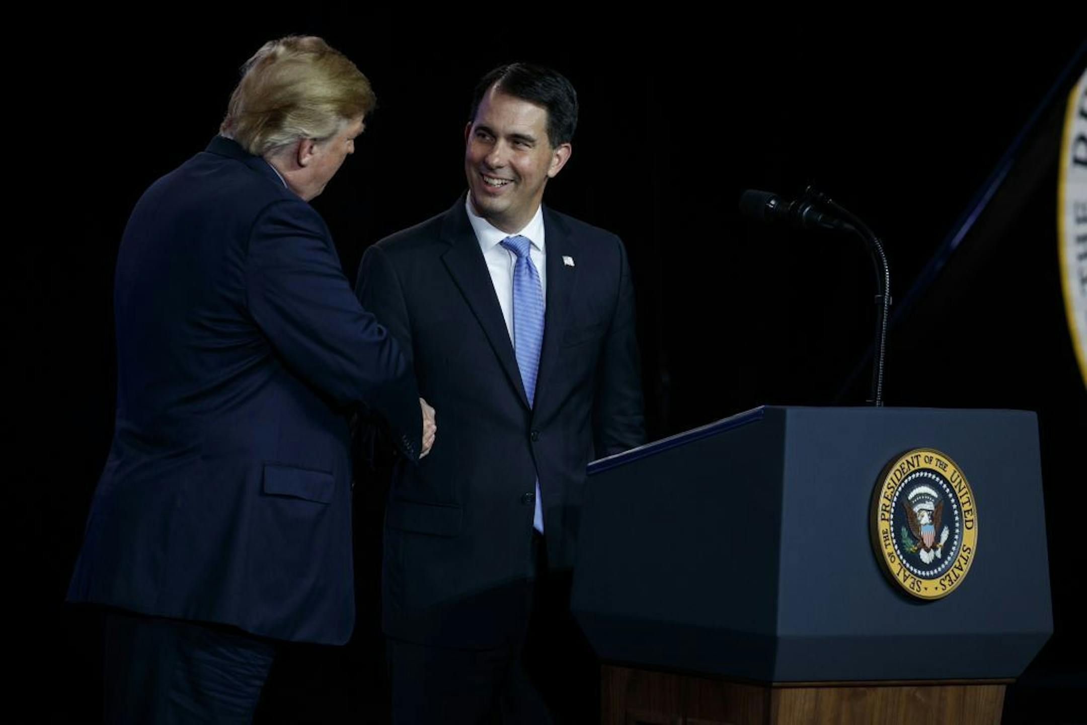 President Donald Trump shakes hands with Gov. Scott Walker, R-Wis., during remarks to a Foxconn facility, Thursday, June 28, 2018, in Mt. Pleasant, Wis.