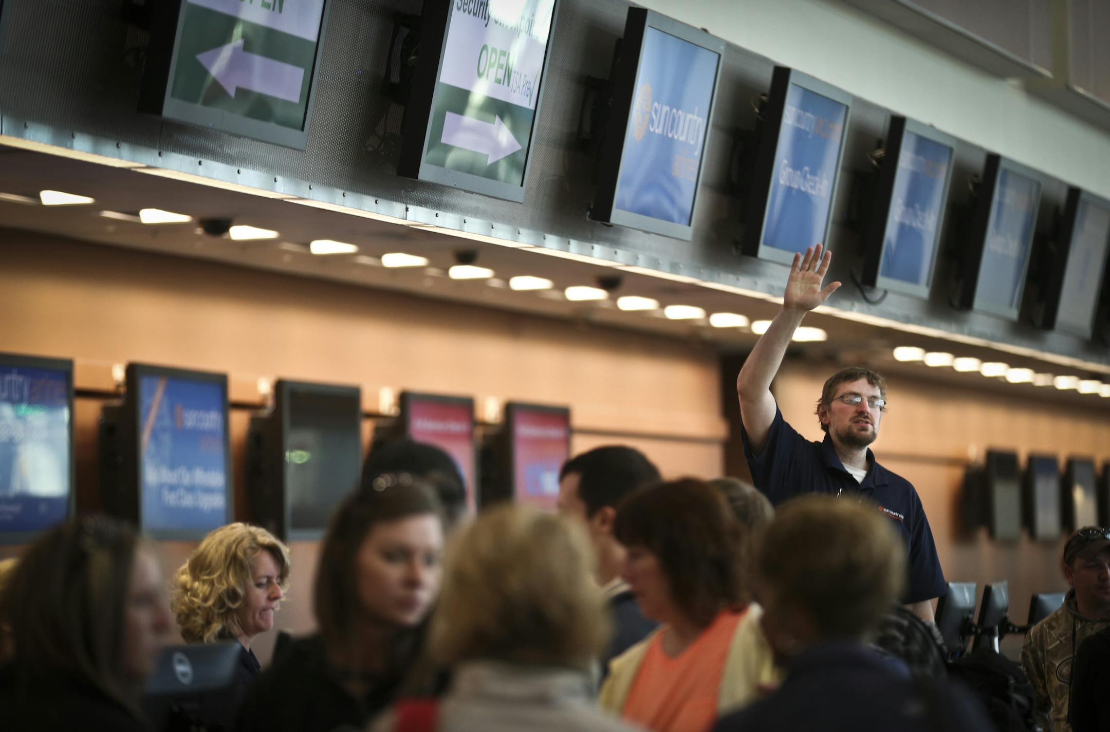 Tim Daniels indicated his ticket counter was ready while checking people in to Sun Country airline at Terminal 2 at the Minneapolis/St. Paul Airport in Bloomington, Minn., on Thursday, April 10, 2014. (RENEE JONES SCHNEIDER • reneejones@startribune.com)