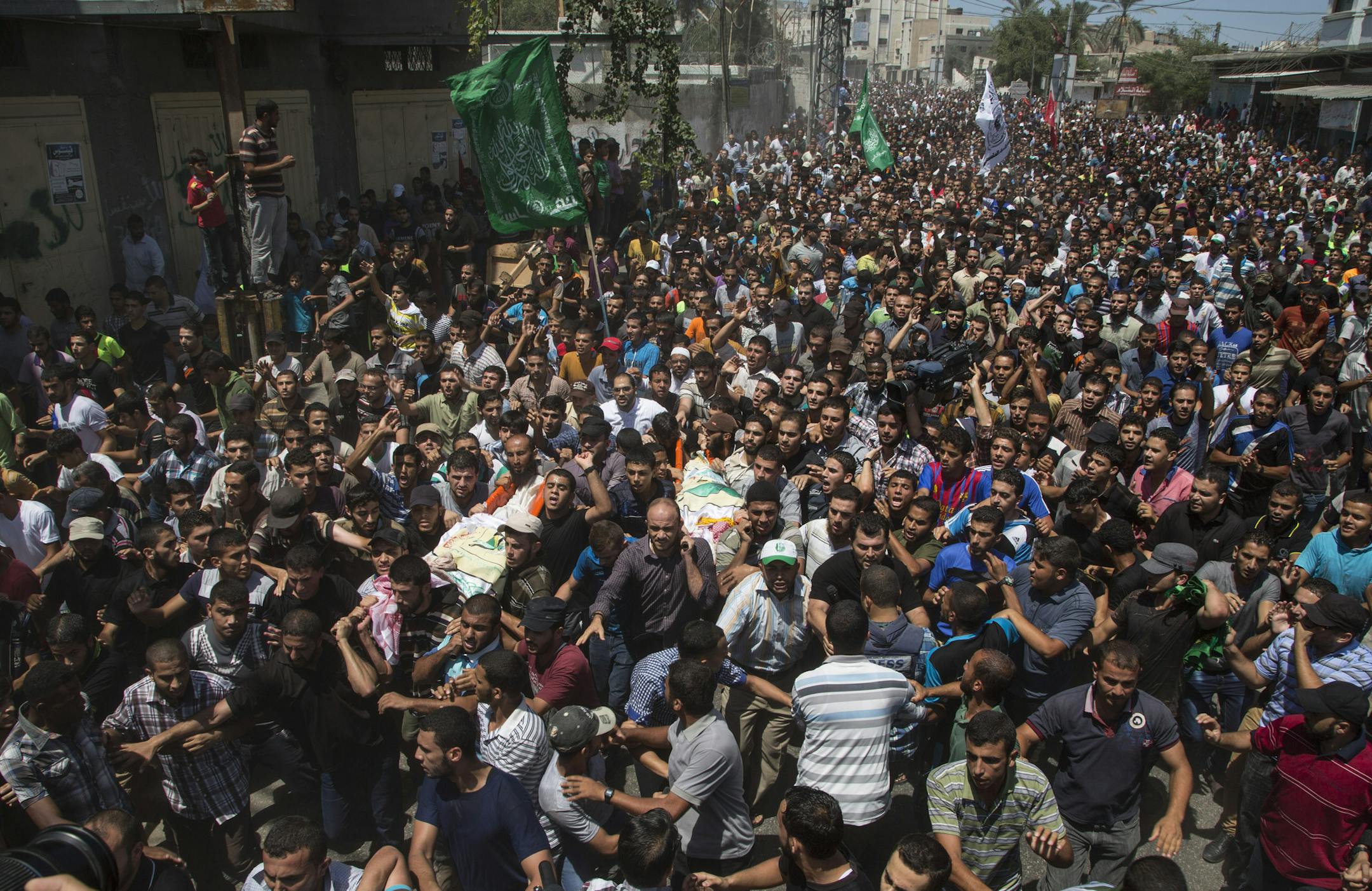 Palestinians carry the bodies of Mohammed Abu Shamaleh and Raed Attar, two senior Hamas commanders killed by Israeli airstrikes, in Rafah in the southern Gaza Strip, Aug. 21, 2014. The airstrikes targeting Hamas military commanders were the most significant blow to the militant group’s leadership since the outbreak of hostilities more than six weeks ago. (Wissam Nassar/The New York Times)