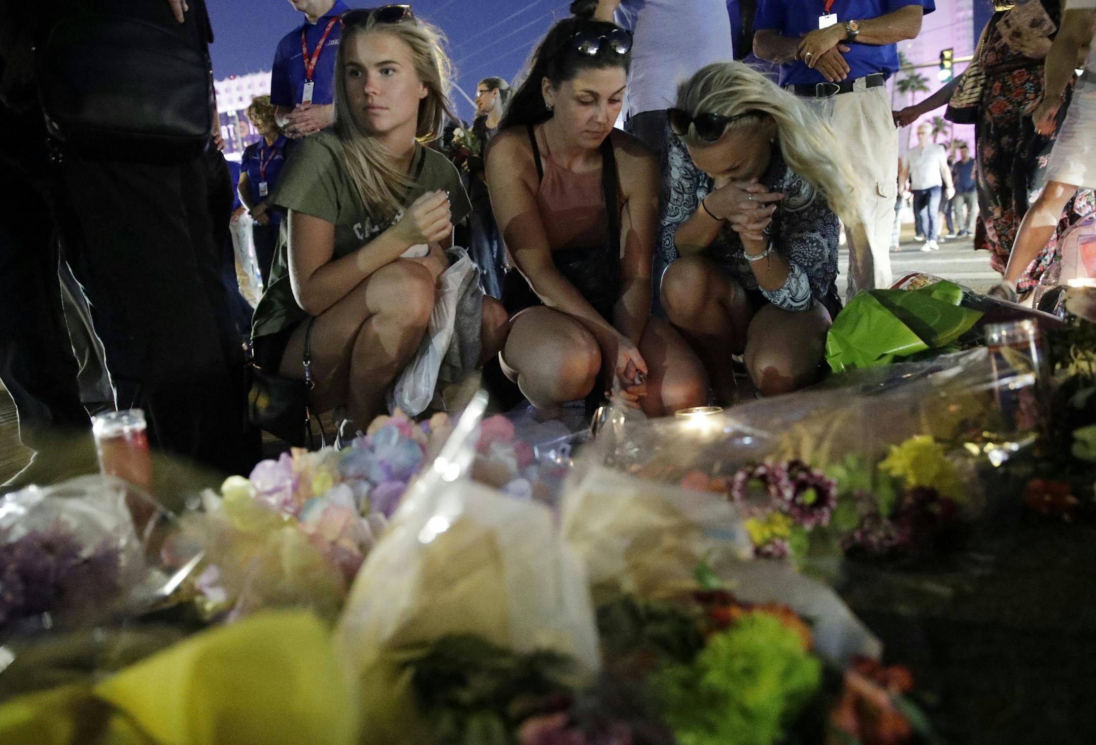 People pause at a memorial set up for victims of a mass shooting in Las Vegas, Nev., on Tuesday, Oct. 3, 2017. A gunman opened fire on an outdoor music concert on Sunday. It was the deadliest mass shooting in modern U.S. history, with dozens of people killed and hundreds injured, some by gunfire, some during the chaotic escape.