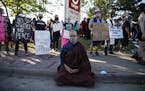 A person meditates near the Minneapolis police 3rd Precinct on Thursday, May 28, 2020, the third day of protests over the Monday death of George Floyd