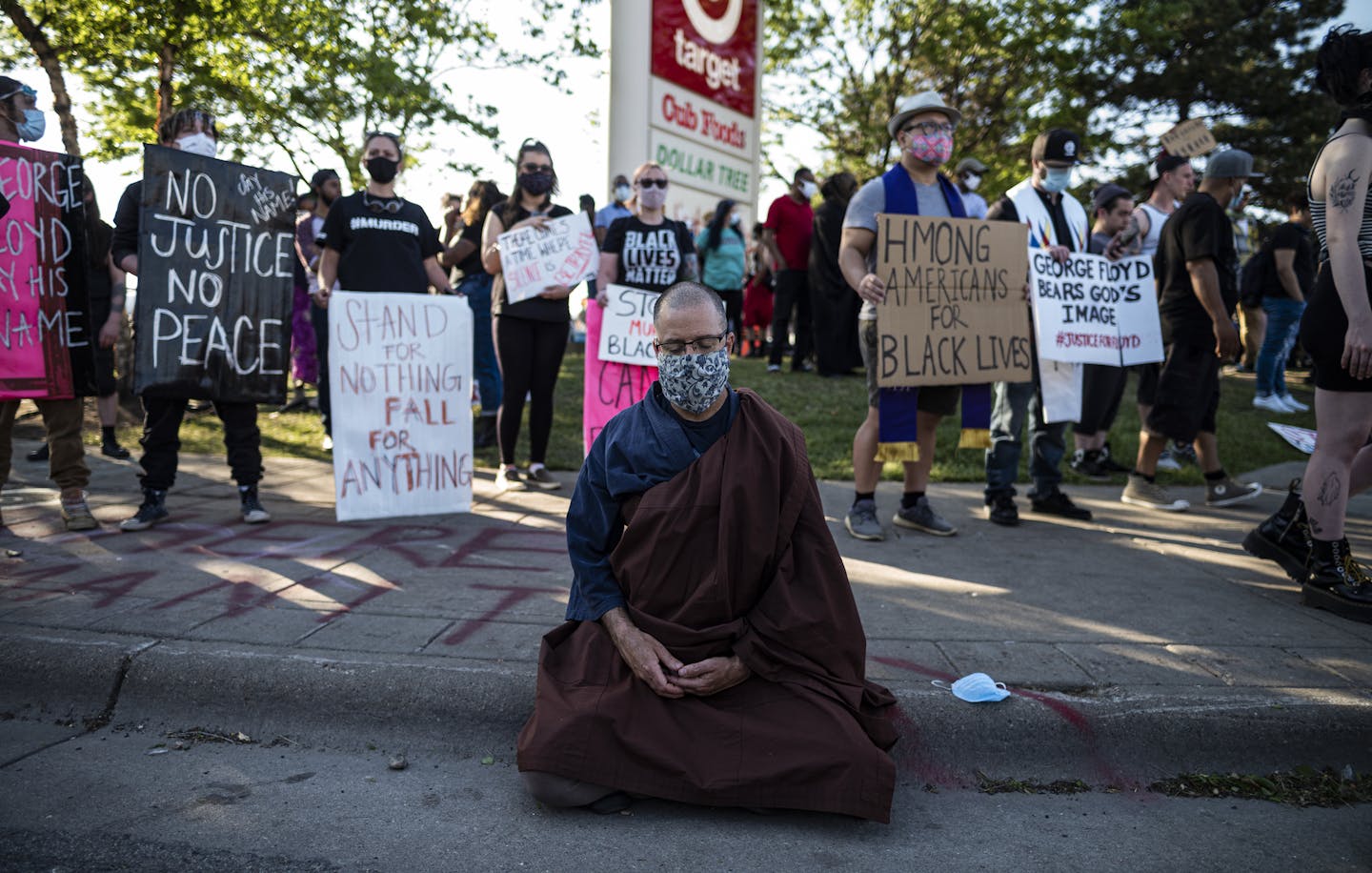 A person meditates near the Minneapolis police 3rd Precinct on Thursday, May 28, 2020, the third day of protests over the Monday death of George Floyd in Minneapolis police custody. (Richard Tsong-Taatarii/Star Tribune via AP)