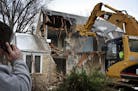 A backhoe operator from Final Grade worked on knocking down a cape cod homeThursday, Feb. 23, 2012, in Edina, MN, in order to build a new home on the 