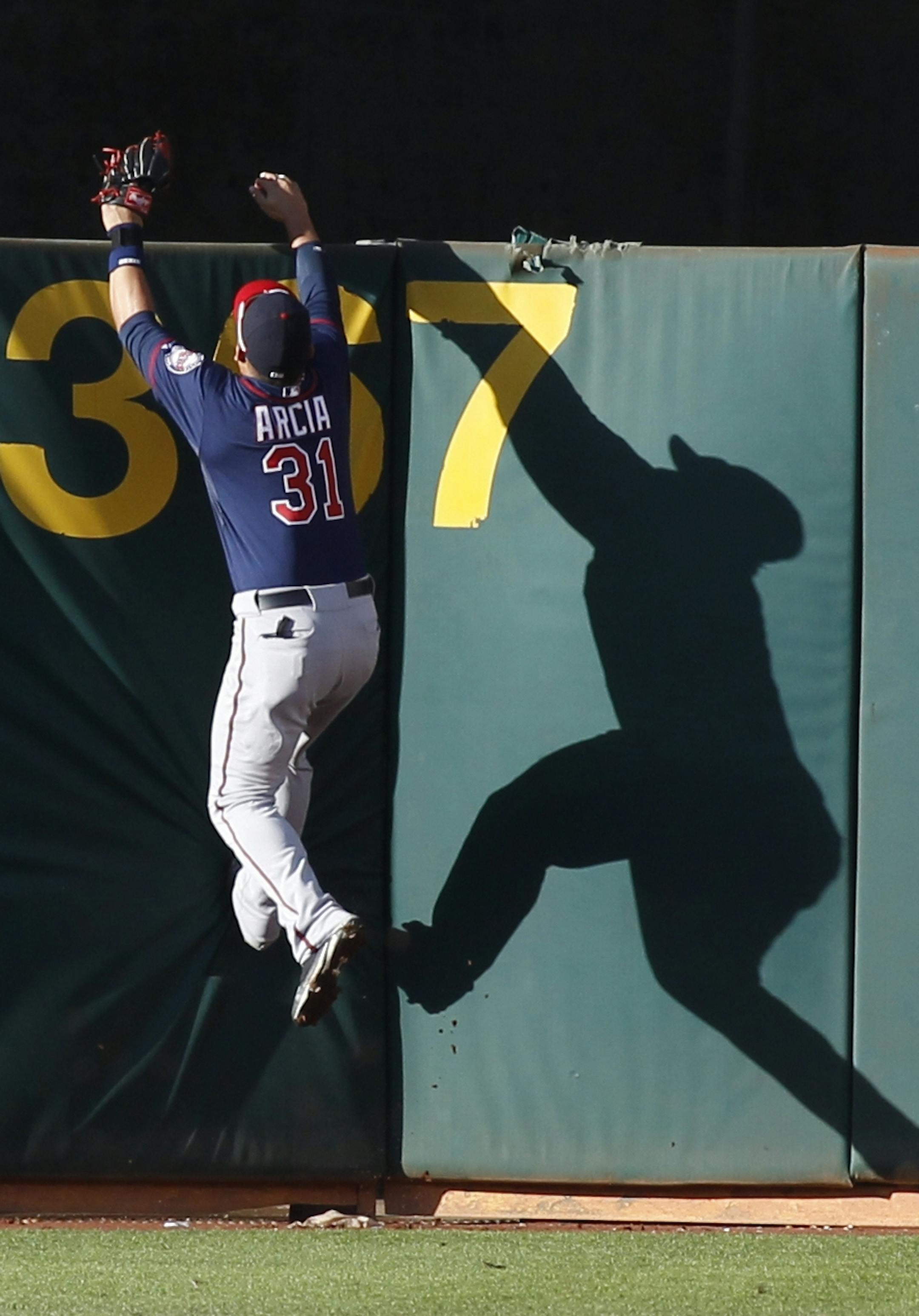 Minnesota Twins' Oswaldo Arcia jumps for a home run by Oakland Athletics' Kurt Suzuki during the seventh inning of a baseball game, Saturday, Sept. 21, 2013, in Oakland, Calif. The Athletics defeated the Twins 9-1. (AP Photo/George Nikitin)
