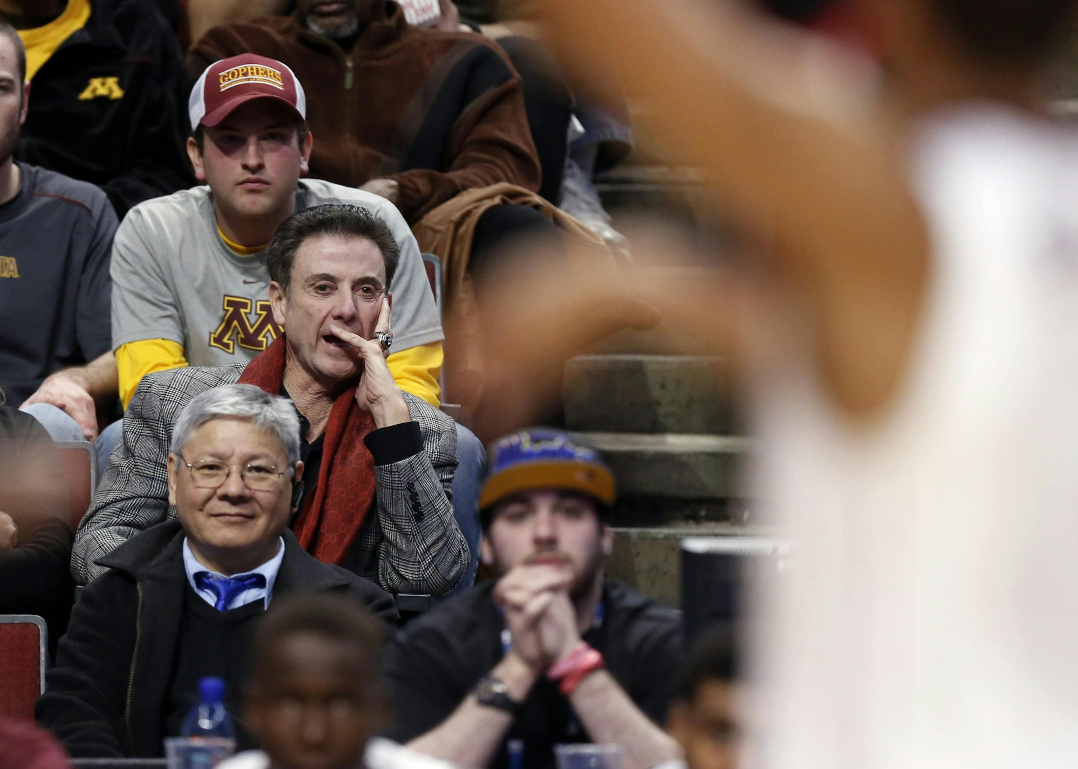 Louisville head coach Rick Pitino watches as his son Minnesota head coach Richard Pitino directs his team in the first half of an NCAA college basketball game between Minnesota and Rutgers in the first round of the Big Ten Conference tournament, Wednesday, March 11, 2015, in Chicago. (AP Photo/Charles Rex Arbogast)