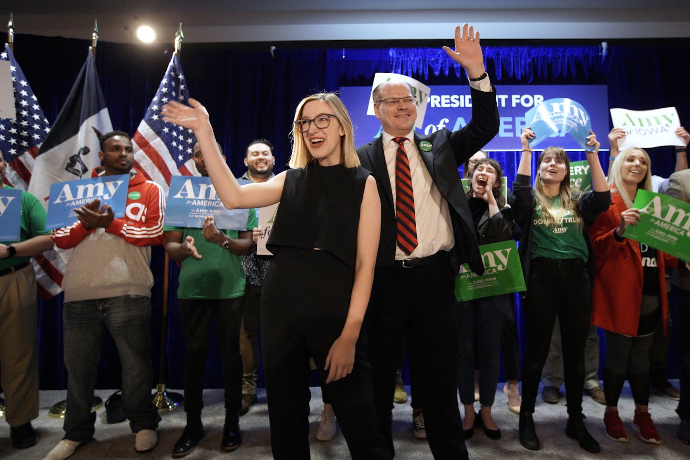 John Bessler, husband of Democratic presidential candidate Sen. Amy Klobuchar, D-Minn., center right, and daughter Abigail Klobuchar Bessler, center left, wave to supporters at her caucus night campaign rally in Des Moines, Iowa, Monday, Feb. 3, 2020. (AP Photo/Nati Harnik)