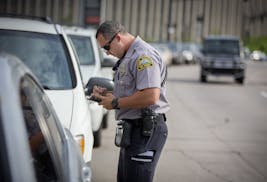 St. Paul Parking Enforcement Officer Joe Hakeem wrote up parking tickets to a couple of cars that were parked in a turn lane near Regions Hospital mak