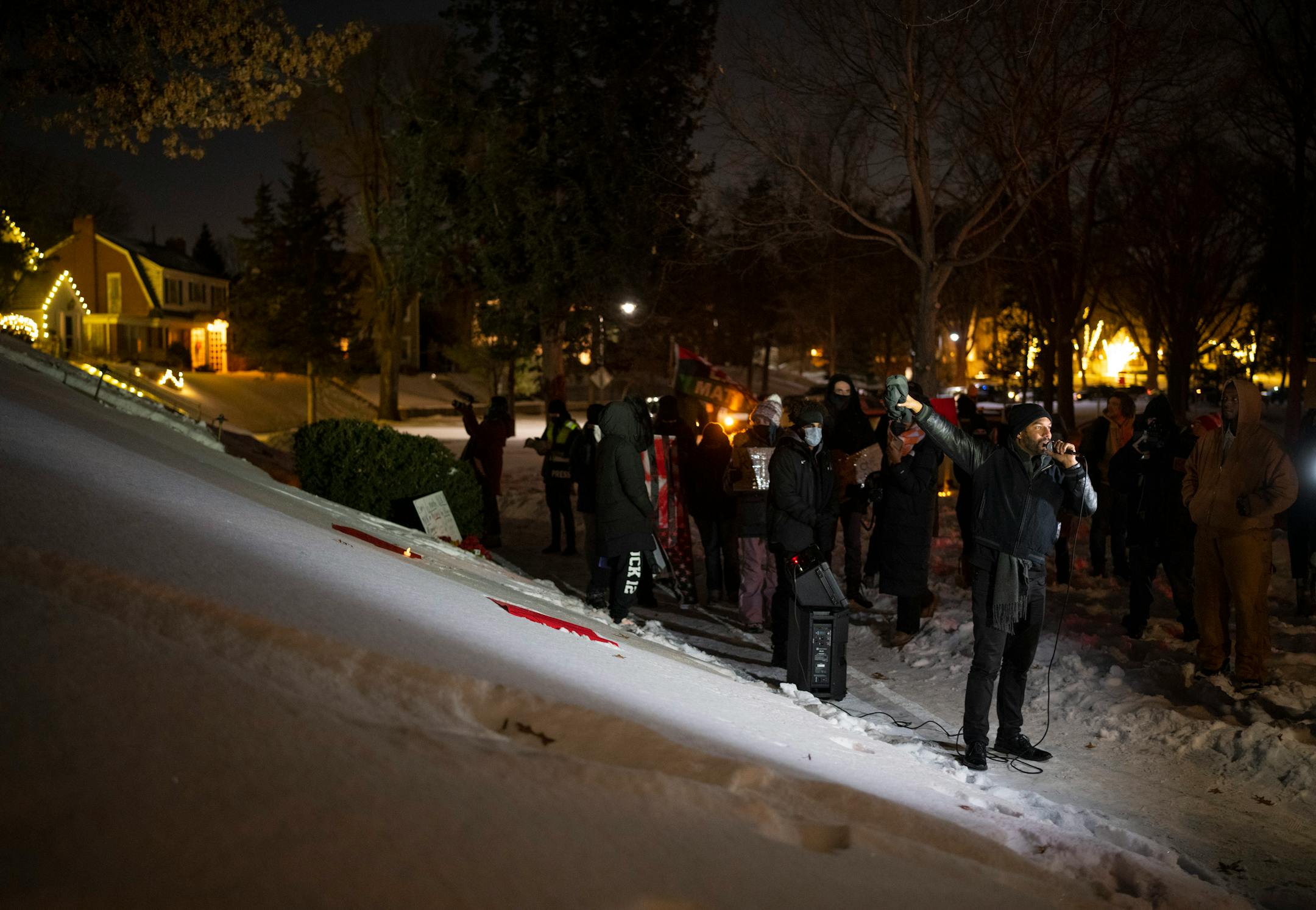 Demonstrators listened to Toussaint Morrison&nbsp;&nbsp;&nbsp; while gathered outside homes in the Cedar-Isles-Dean on Sunday night, February 6, 2022 in Minneapolis.