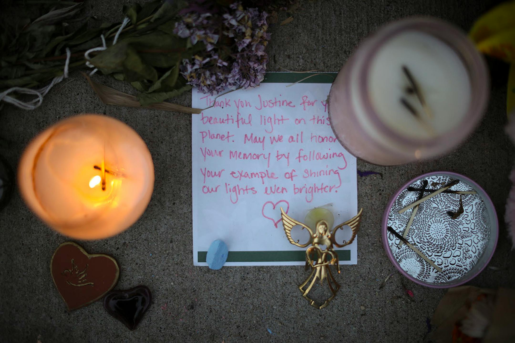 Some candles were lit as darkness fell at the memorial to Justine Damond on the sidewalk along W 51st. St. Monday night.