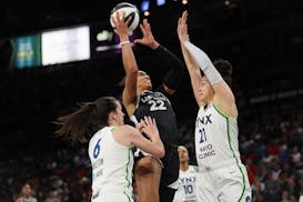 Aces center A'ja Wilson (22) shoots against Lynx forward Bridget Carleton (6) and guard Kayla McBride (21) during the first half Tuesday in Las Vegas.