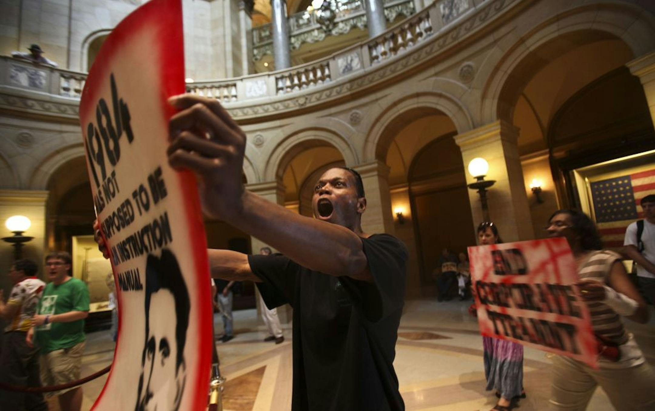 C. J. Turner, of Minneapolis, chanted to tax the rich during a protest in the rotunda at the state capitol with hours left until a government shutdown.