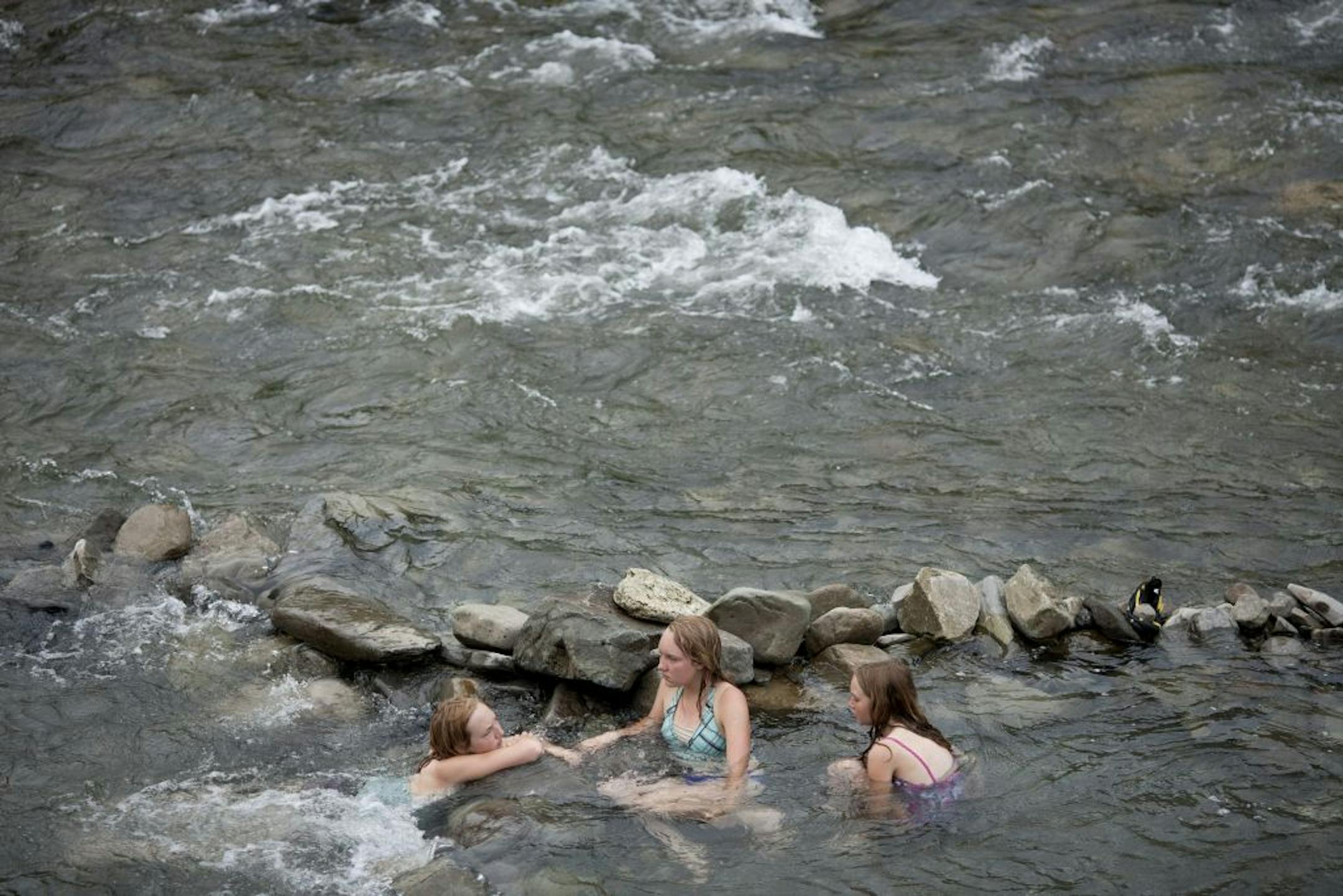 Visitors soak in a natural formed jacuzzi in the Boiling River, where a large hot spring mixes with the cold Gardner River, in the Mammoth area of Yellowstone National Park in Wyoming. Mammoth, on the park's northern border with Montana, is known for its grazing elk above an elaborate network of ever-shifting terraced hot springs.