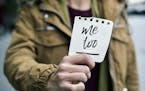 closeup of a young caucasian woman in the street showing a piece of paper with the text me too written in it. istock