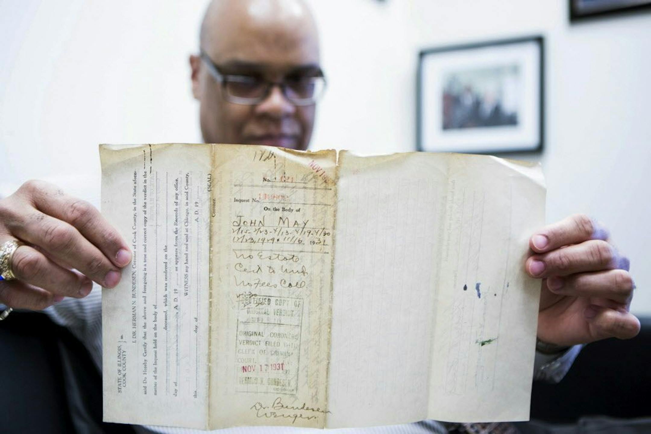 In this Thursday, Feb. 11, 2016 photo, James Sledge, an executive officer at the Cook County Medical Examiner�s office in Chicago, holds one of the original autopsy reports from the infamous Valentine's Day massacre 87 years ago. Sledge, a local history buff, asked if he could look at the reports from the attack that left seven men dead in a Chicago garage and widely believed to have been ordered by Al Capone. Sledge�s staff made multiple trips to a government warehouse before they found the pap