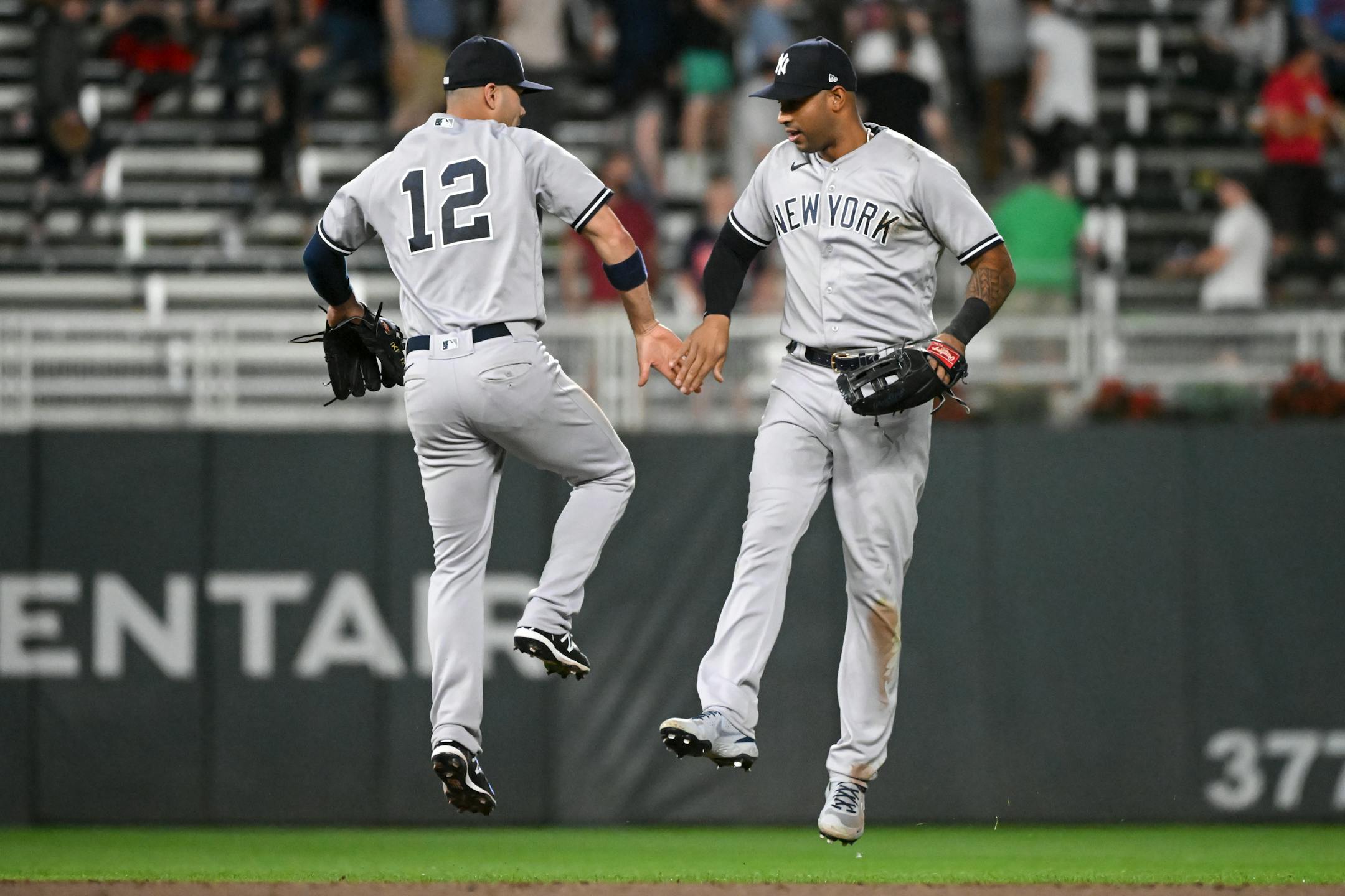 New York Yankees shortstop Isiah Kiner-Falefa (12) and left fielder Aaron Hicks (31) celebrate after their team's 10-7 victory against the Minnesota Twins.