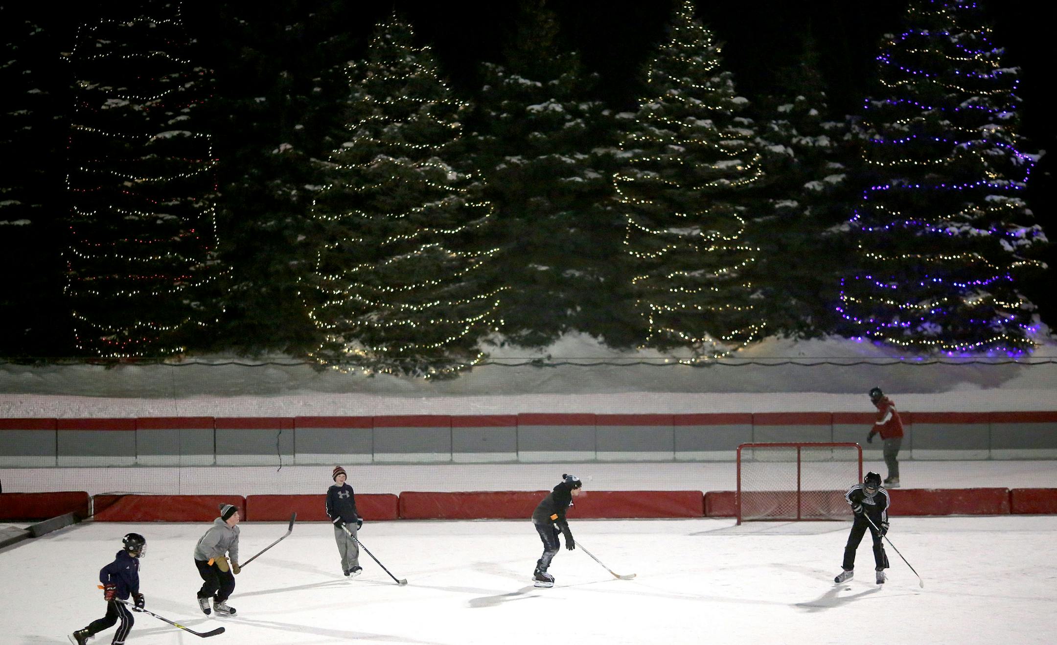 Hockey players batted around the puck as skater went around the Oval on New Year's Eve. ] (KYNDELL HARKNESS/STAR TRIBUNE) kyndell.harkness@startribune.com Open skate at John Rose Oval in Roseville Min., Wednesday, December 31, 2014.