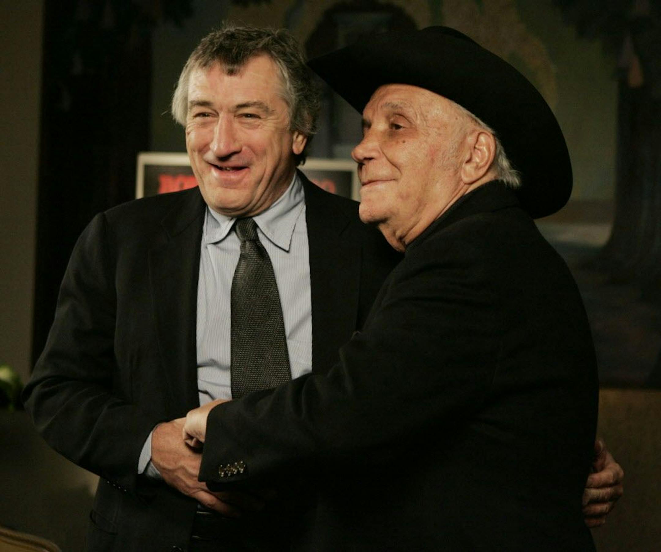 FILE - In this Jan. 27, 2005, file photo, Robert DeNiro, left, and boxer Jake LaMotta stand for photographers before watching a 25th anniversary screening of the movie "Raging Bull" in New York. LaMotta, whose life was depicted in the film �Raging Bull,� died Tuesday, Sept. 19, 2017, at a Miami-area hospital from complications of pneumonia. He was 95.