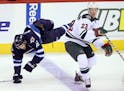 FILE - Winnipeg Jets' Andrew Ladd (16) goes over the back of Minnesota Wild's Gustav Olofsson (23) during first period pre-season NHL hockey action at