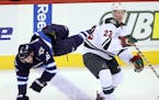 FILE - Winnipeg Jets' Andrew Ladd (16) goes over the back of Minnesota Wild's Gustav Olofsson (23) during first period pre-season NHL hockey action at