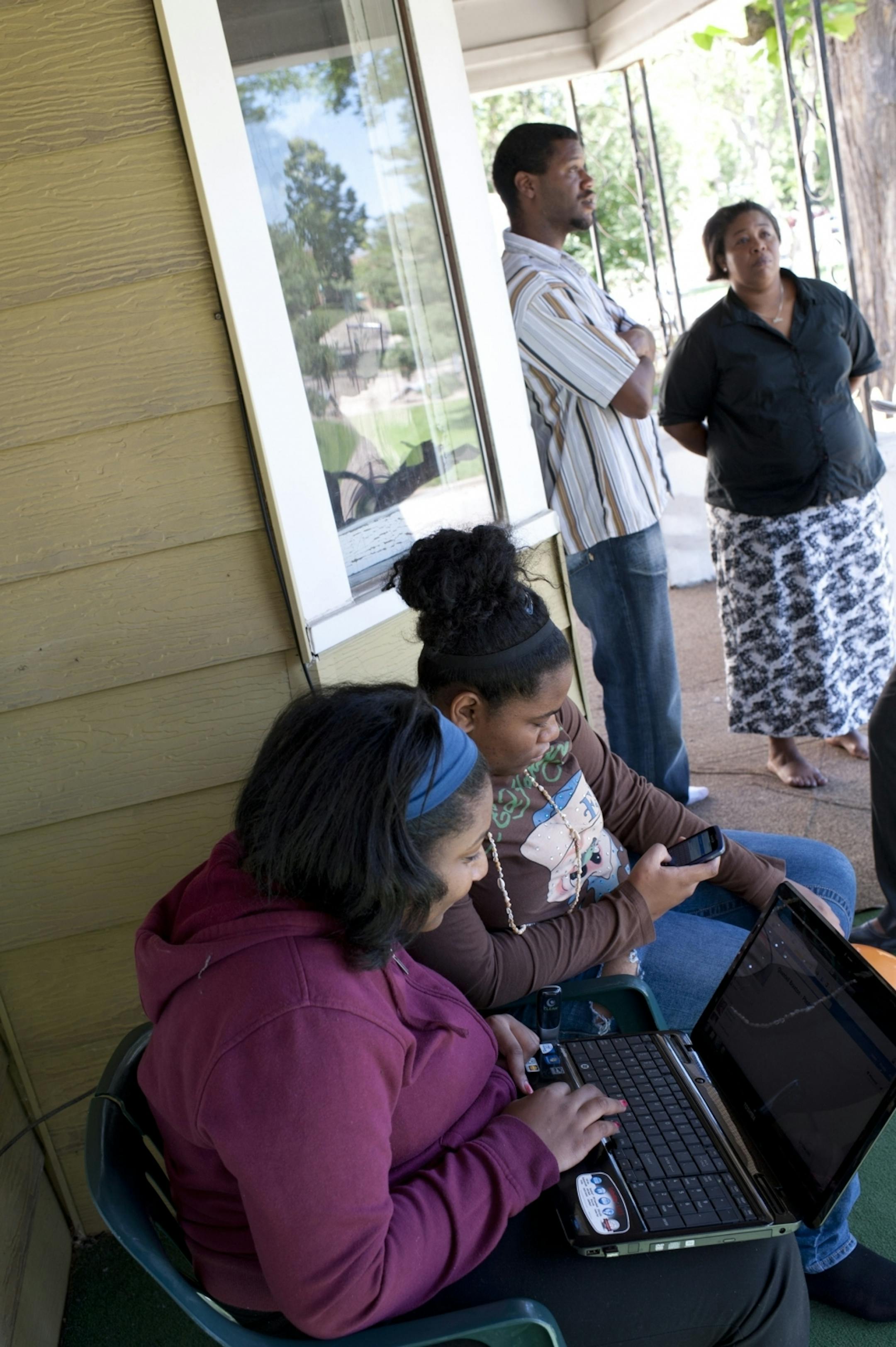 Quantell Braxton's aunts Mimi and Gabrielle Odom looked through comments on his Facebook page while his mother, Cindy Braxton, and father, Derrick Kennedy, spoke on their front porch.