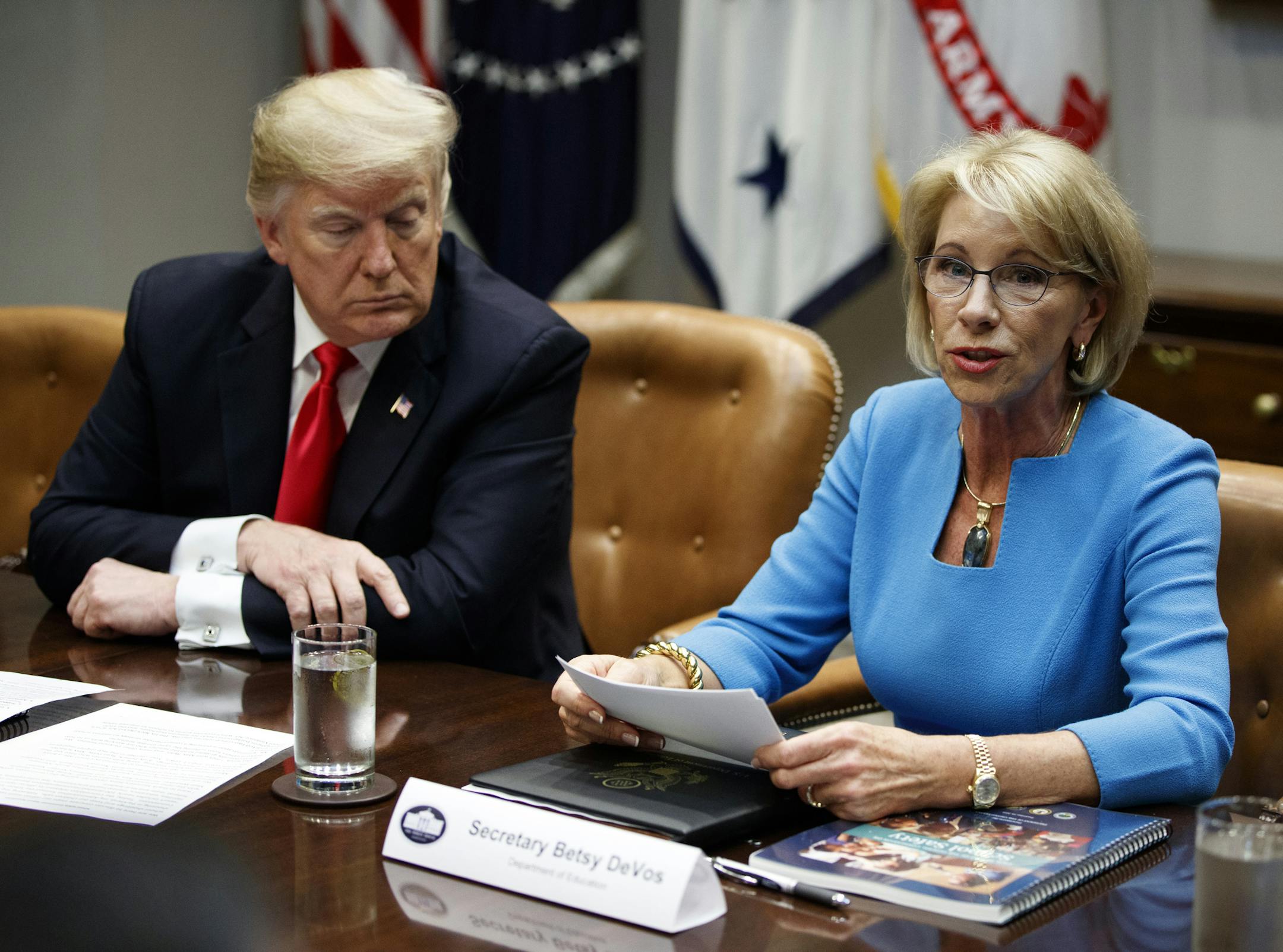 President Donald Trump listens as Secretary of Education Betsy DeVos speaks during a roundtable discussion on the Federal Commission on School Safety report, in the Roosevelt Room of the White House, Tuesday, Dec. 18, 2018, in Washington.