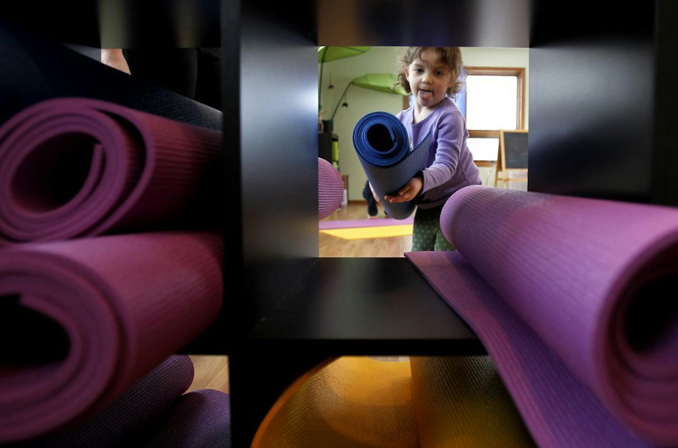 Cora Spanier 3, put her yoga mat away after a class with her mother Kelcie Hoes.