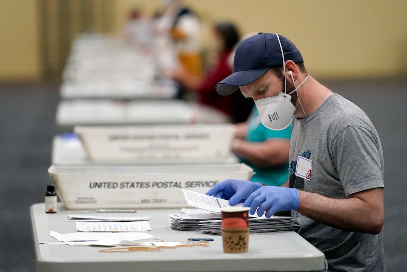 Workers prepare mail-in ballots for counting, Wednesday, Nov. 4, 2020, at the convention center in Lancaster, Pa., following Tuesday's election. (AP Photo/Julio Cortez)