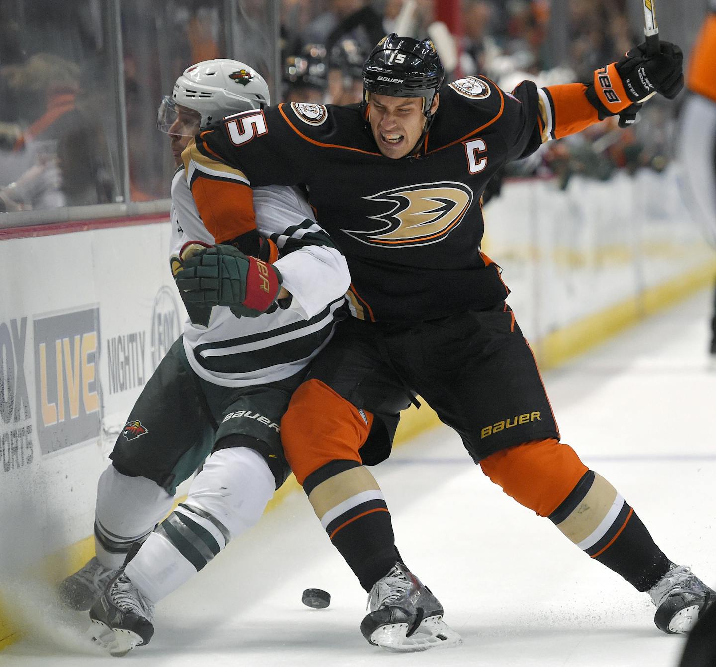 Anaheim Ducks center Ryan Getzlaf, right, puts Minnesota Wild right wing Justin Fontaine into the boards during the first period an NHL hockey game Friday, Oct. 17, 2014, in Anaheim, Calif. (AP Photo/Mark J. Terrill)