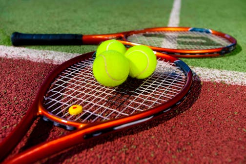 Tennis Rackets and balls on the court.