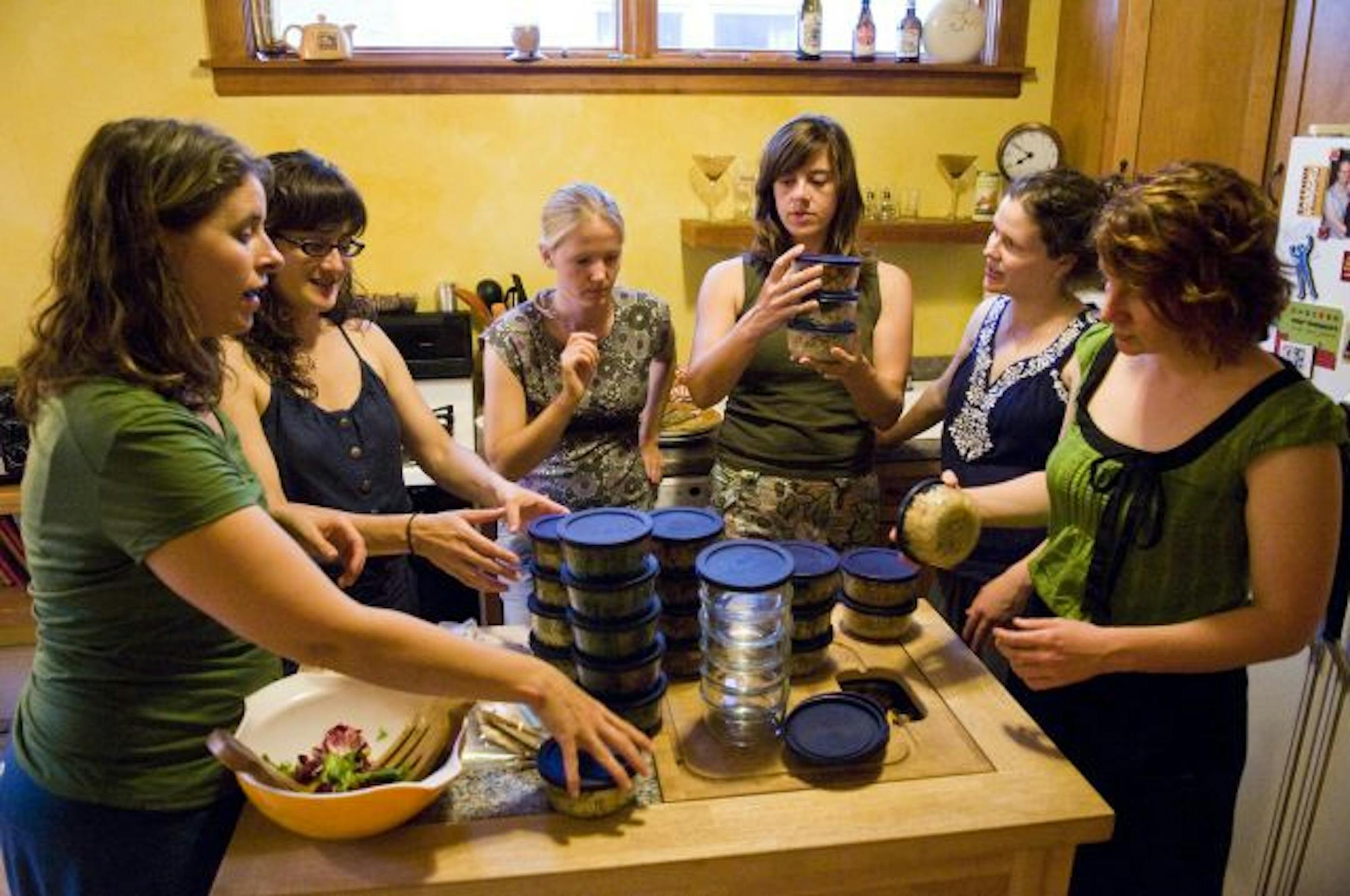From left: Megan Simmons of Minneapolis, Barbara Martinez of St. Paul, Karen Krueger Slaght of St. Paul, Julie Pearson of St. Paul, Anna Mason of Minneapolis and Lesley Kadish of St. Paul swap lunches for the 130th time in Pearson's home on Aug. 1. These six women have been swapping meals, recipes and cooking techniques every other week for 5 years. Each woman is responsible for supplying five small portions of food for their friends to taste later in the week.