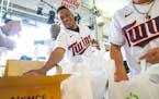 Minnesota Twins infielder Jorge Polanco helps pack non-perishable food with teammates.