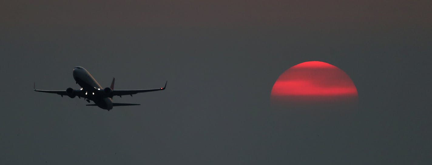 A jet takes flight over MSP under a setting sun as haze from Canada wild fires partially obscures the sunset Sunday, Aug. 13, 2018, in Mendota Heights, MN.] DAVID JOLES &#xef; david.joles@startribune.com Haze from Canada wild fires has been obscuring the sunset for the past several days.