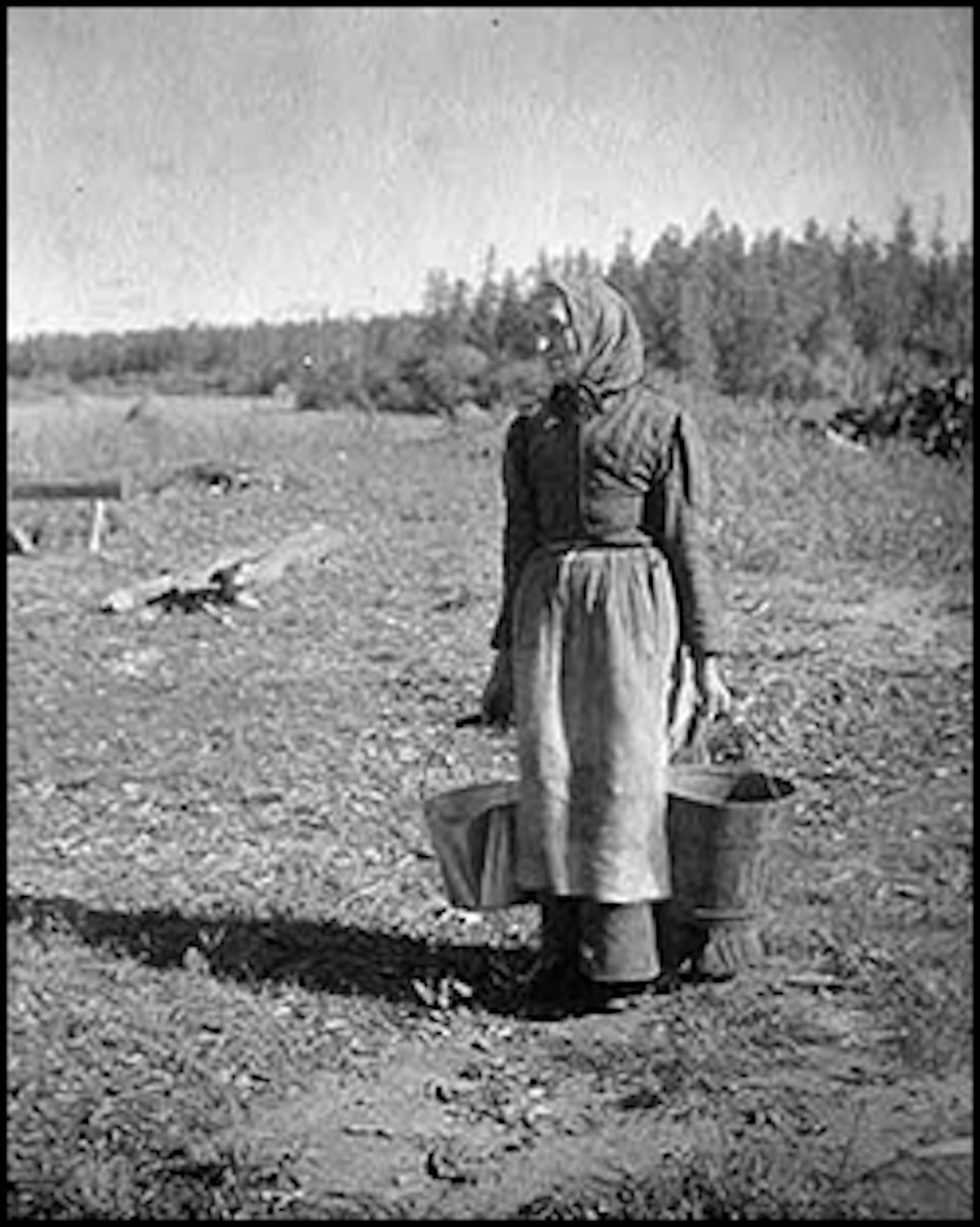 Frontier and pioneer life: Woman carrying pails, about 1900