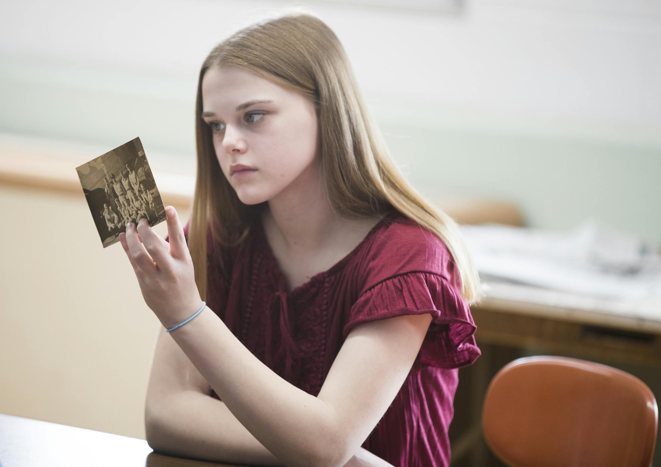 Eighth grader Becky Dammann looks at the original photo of her teacher Dean Sheele's father's WWII bomber crew.