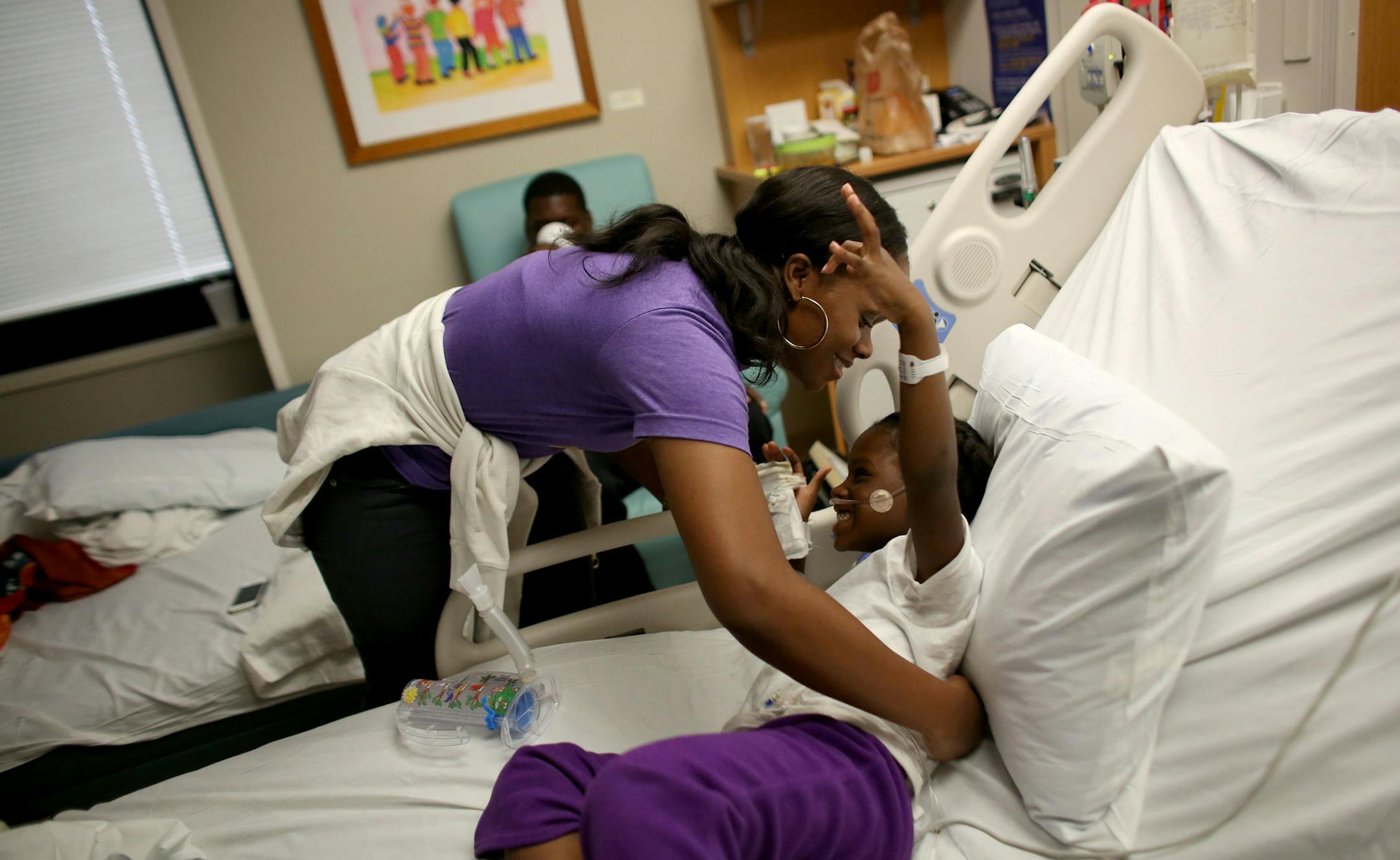 Kennedy Smith, 4, of Brooklyn Park, got a hug from her mother Leslie, in her hospital bed as she recovers from her respiratory trouble. ] (KYNDELL HARKNESS/STAR TRIBUNE) kyndell.harkness@startribune.com At Children's Hospital in Minneapolis Min., Thursday, September 11, 2014.