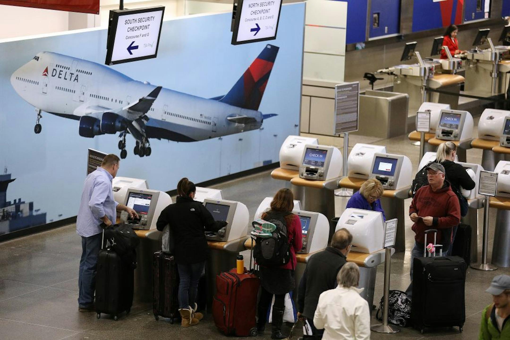 Travelers check in at the Delta ticketing counter Saturday.