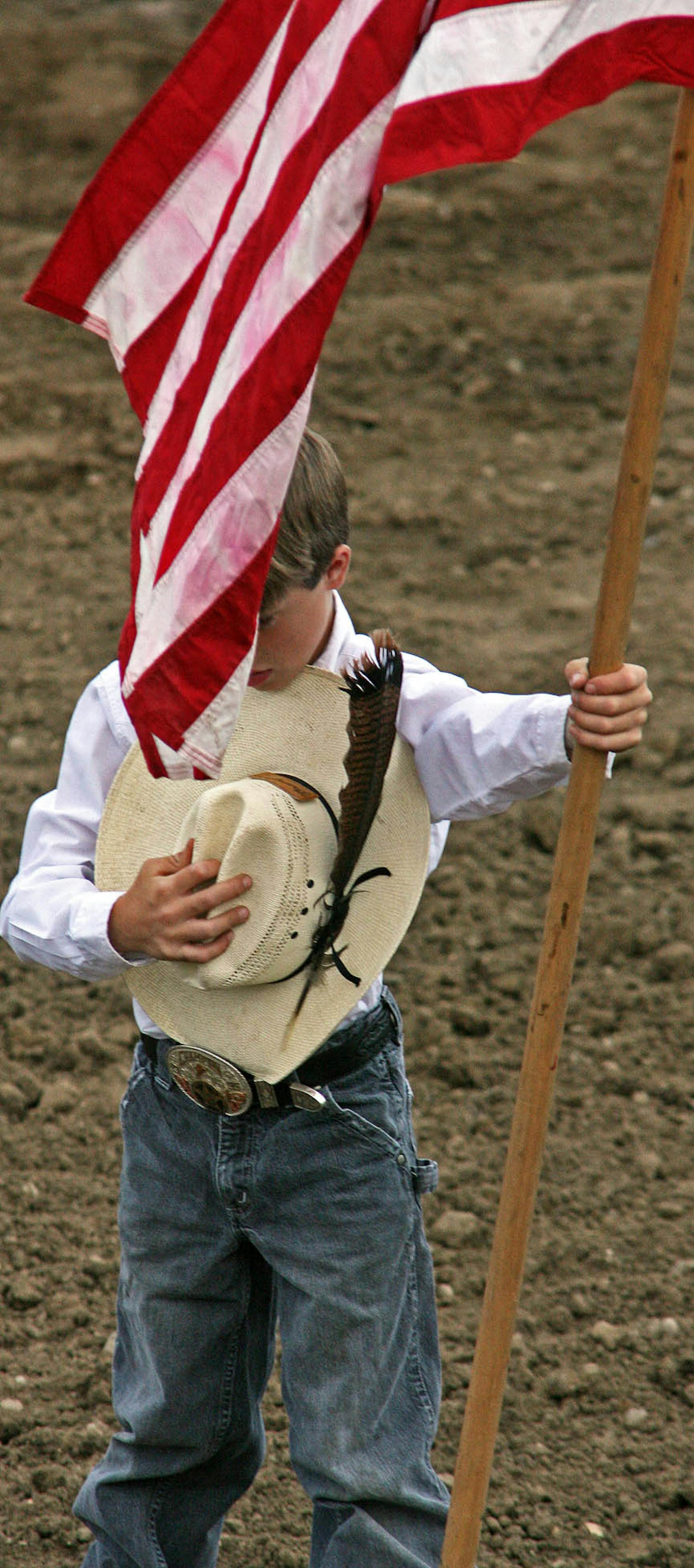 MARLIN LEVISON * mlevison@startribune.com Assign. #00003996A July 23, 2008] - GENERAL INFORMATION: Bull Riding contest as part of the Anoka County Fair. IN THIS PHOTO: A little cowboy carried the flag into the arena. ORG XMIT: MIN2013071613463144