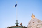 Charlie Krueger, a grounds supervisor for facilities management at the Department of Administration, raises the new Minnesota state flag for the first